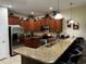 Well-equipped kitchen with stainless steel appliances, granite countertops, and wooden cabinets at 1439 Moon Valley Dr, Davenport, FL 33896