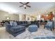 Spacious living room with tile floors, a large sectional sofa, and stylish decor at 1439 Moon Valley Dr, Davenport, FL 33896