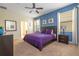 Bright and airy main bedroom with a blue accent wall, carpeted floors, and ensuite bathroom at 1439 Moon Valley Dr, Davenport, FL 33896