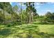 Beautiful backyard featuring lush green grass, mature trees, and outdoor seating at 149 Spanish Bay Dr, Sanford, FL 32771