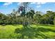 Expansive backyard with lush green grass, mature trees, a bench, and a swing set at 149 Spanish Bay Dr, Sanford, FL 32771