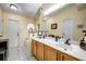 Well-lit bathroom with white tile floors, a long vanity, and a large mirror reflecting natural light at 149 Spanish Bay Dr, Sanford, FL 32771