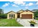 Charming home featuring manicured lawn, stone pathway, and a well-kept two-car garage at 149 Spanish Bay Dr, Sanford, FL 32771