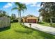 Well-maintained home featuring a lush lawn, mature trees, and a charming two-car garage at 149 Spanish Bay Dr, Sanford, FL 32771