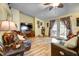 Inviting living room showcasing wood floors, a large TV, comfortable leather seating, and access to outdoor space at 149 Spanish Bay Dr, Sanford, FL 32771