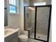 Modern bathroom with a glass-enclosed shower, gray vanity, and sleek fixtures at 15107 Grove Lake Dr, Winter Garden, FL 34787