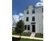 Charming three-story townhome with a modern white facade and a well-manicured front lawn at 15107 Grove Lake Dr, Winter Garden, FL 34787