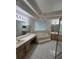 Large bathroom featuring a jacuzzi tub, dual sinks, and a glass-enclosed shower at 1586 Antoinette Ct, Oviedo, FL 32765