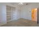Carpeted bedroom features built-in bookcase, closet, and en-suite bathroom with neutral color palette at 1586 Antoinette Ct, Oviedo, FL 32765