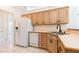 Well-lit kitchen with stainless steel sink, wood cabinets, and white appliances at 1586 Antoinette Ct, Oviedo, FL 32765