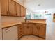 Kitchen with stainless steel sink, wood cabinetry and view to connected living area at 1586 Antoinette Ct, Oviedo, FL 32765