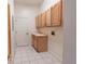 A laundry room with tile floor, utility sink and wall-mounted cabinets at 1586 Antoinette Ct, Oviedo, FL 32765
