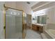 Main bathroom with walk-in glass shower, vanity, tub, and vertically striped wallpaper at 1586 Antoinette Ct, Oviedo, FL 32765