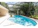 A sparkling pool surrounded by lush plants in the screened in enclosure at 1586 Antoinette Ct, Oviedo, FL 32765