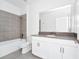 Bathroom features a gray quartz countertop, white cabinets, tile flooring, and tiled shower walls at 1596 Contentment Loop, Kissimmee, FL 34744