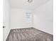 Cozy bedroom with plush gray carpeting and bright natural light from the window at 1596 Contentment Loop, Kissimmee, FL 34744