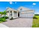 Inviting single-Gathering home with lush landscaping, a paved driveway, and a two-car garage at 1596 Contentment Loop, Kissimmee, FL 34744