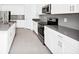 Well-equipped kitchen with stainless steel appliances, gray countertops, and white cabinetry at 1596 Contentment Loop, Kissimmee, FL 34744