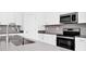 Modern kitchen featuring stainless steel appliances, gray countertops, and sleek white cabinets at 1596 Contentment Loop, Kissimmee, FL 34744