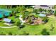 Aerial view of a community playground with picnic shelters and a tennis court surrounded by green spaces at 1596 Contentment Loop, Kissimmee, FL 34744