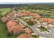 Aerial view of a neighborhood with a community pool, lush lawns, and beautiful terra cotta roofs at 1705 Saint Tropez Ct, Kissimmee, FL 34744