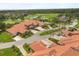 Beautiful aerial view of community homes near a golf course with mature landscaping and terra cotta roofs at 1705 Saint Tropez Ct, Kissimmee, FL 34744