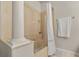 Bathroom with a shower and tub combination featuring a glass enclosure, a large pillar, and tile surround at 1705 Saint Tropez Ct, Kissimmee, FL 34744