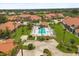 Aerial view of a community pool with lounge chairs and landscaping among beautiful homes at 1705 Saint Tropez Ct, Kissimmee, FL 34744