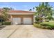 Spacious two-car garage featuring an extra wide driveway and landscaping at 1705 Saint Tropez Ct, Kissimmee, FL 34744