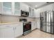 Well-lit kitchen with white cabinets, stainless steel appliances, and tile flooring at 1705 Saint Tropez Ct, Kissimmee, FL 34744