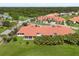Aerial shot of a home with a large grass lawn and terra cotta roof in a well-maintained community at 1705 Saint Tropez Ct, Kissimmee, FL 34744