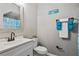 Cozy bathroom with a classic vanity, toilet, and tiled shower, accented with blue and white decor at 17516 Blessing Dr, Clermont, FL 34714