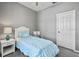 Comfortable bedroom features neutral walls, a ceiling fan, a side table, and a neatly made bed with blue accents at 17516 Blessing Dr, Clermont, FL 34714