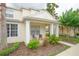 Charming townhouse with a covered front porch, lush landscaping, and two outdoor chairs at 17516 Blessing Dr, Clermont, FL 34714
