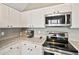 Well-equipped kitchen featuring white cabinets, granite countertops, and stainless steel appliances at 17516 Blessing Dr, Clermont, FL 34714