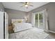 Bright main bedroom with a ceiling fan, balcony access, and neutral decor creates a serene and inviting atmosphere at 17516 Blessing Dr, Clermont, FL 34714