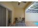 Covered patio with ceiling fan, sliding glass doors, and decorative rug with two chairs offering a relaxing outdoor space at 17516 Blessing Dr, Clermont, FL 34714