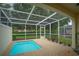 Screened-in pool area with a small splash pool and brick-paved deck surrounded by mature trees and lush landscaping at 17516 Blessing Dr, Clermont, FL 34714