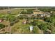 Wide aerial shot featuring the house, barn, and vast land with diverse vegetation and open fields at 17952 Lookout Hill Rd, Winter Garden, FL 34787