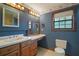 Bathroom with vanity, wood cabinets, and a large window at 17952 Lookout Hill Rd, Winter Garden, FL 34787