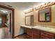 Bathroom vanity with wood cabinets, white countertop, and light sconces at 17952 Lookout Hill Rd, Winter Garden, FL 34787