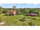 Aerial view of a home with a barn surrounded by green grass and mature trees on a sprawling lot at 17952 Lookout Hill Rd, Winter Garden, FL 34787