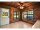 Sunroom featuring wood-paneled walls, ceiling fan, tile flooring, and natural light at 17952 Lookout Hill Rd, Winter Garden, FL 34787