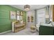 Charming Bedroom featuring a wooden crib, decorative green wall, and ample natural light at 1916 Diamond Head Cir, Lake Hamilton, FL 33851