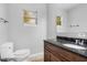 Bathroom features dark granite countertop, wood vanity, toilet, and mirror at 1961 Winter Park Rd, Winter Park, FL 32789