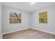 Neutral bedroom with wood laminate floors, two windows, and baseboard trim at 1961 Winter Park Rd, Winter Park, FL 32789