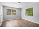 Bright bedroom features wood-look floors, two windows, and neutral gray walls at 1961 Winter Park Rd, Winter Park, FL 32789