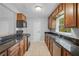Well-lit kitchen featuring black countertops, wood cabinets, and black appliances at 1961 Winter Park Rd, Winter Park, FL 32789
