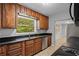 Kitchen featuring black countertops, wood cabinets, and a window overlooking the yard at 1961 Winter Park Rd, Winter Park, FL 32789