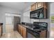 Kitchen featuring black countertops, wood cabinets, and an overhead microwave at 1961 Winter Park Rd, Winter Park, FL 32789
